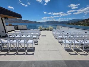 a row of white chairs on the roof of a building at Lakeview Main Floor Suite 104 in Peachland
