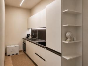 a kitchen with white cabinets and a sink at Casa Vacanza Saint George - Hotel San Giuseppe Group in Cernobbio