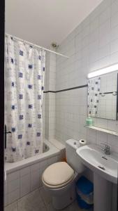 a white bathroom with a toilet and a sink at Los Hermanos in Viladecáns