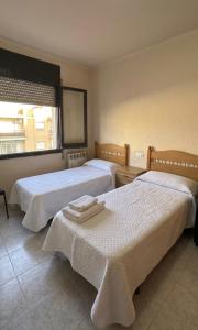 a bedroom with two beds and a window at Los Hermanos in Viladecáns