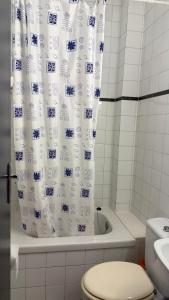 a bathroom with a toilet and a shower curtain at Los Hermanos in Viladecáns