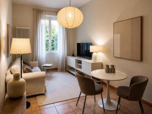 a living room with a couch and a table with chairs at Casa Vacanza Saint George - Hotel San Giuseppe Group in Cernobbio