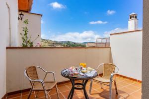 a table and chairs on a balcony with a view at Hotel Balcón de los Montes in Colmenar