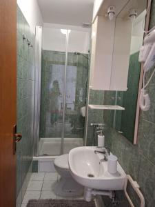 a bathroom with a sink and a shower and a toilet at RETRO Apartments in Bjelovar +24 photos
