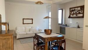 a kitchen and living room with a table and a couch at Terrazzo Vista Mare Mozzafiato in Cariati