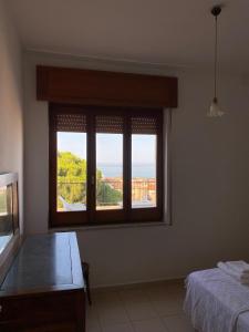 a bedroom with a window with a view of the ocean at Terrazzo Vista Mare Mozzafiato in Cariati +12 photos