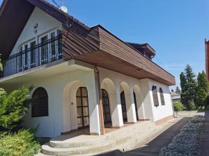 a house with a balcony on top of it at Kossuth Apartman in Hajdúszoboszló