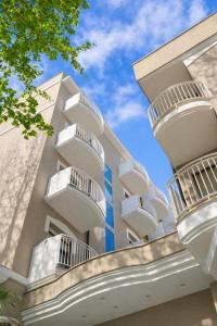 a white building with balconies on the side of it at Dipendenza Hotel Regal in Rimini