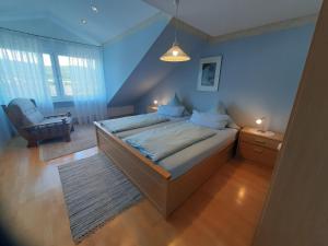 a bedroom with a bed and a chair in it at Ferienwohnung Purwins in Ebermannstadt