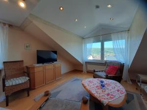 a living room with a tv and a table and chairs at Ferienwohnung Purwins in Ebermannstadt