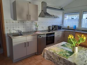a kitchen with white cabinets and a sink and a table at Ferienwohnung Purwins in Ebermannstadt