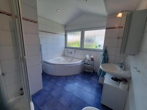 a bathroom with a tub and a sink at Ferienwohnung Purwins in Ebermannstadt