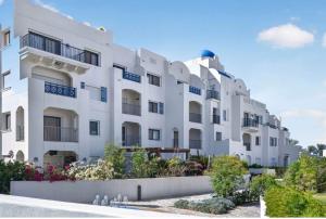 a large white building with flowers in front of it at Marassi in El Alamein