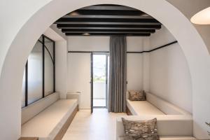 a living room with white furniture and an archway at Veneto Sea View Apartments in Stalís