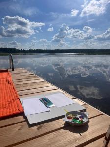 a wooden dock with a table with a bowl of food on it at Siedlisko Żywe Kamienie in Naguszewo