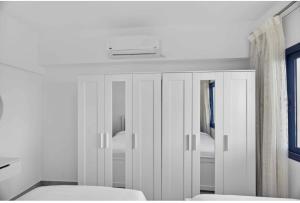 a bedroom with a white cabinet with a mirror at Marassi in El Alamein +19 photos