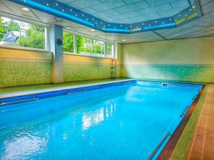 an indoor swimming pool with blue water in a room at RELAX - ORANGE mit Pool und Sauna in Sonthofen