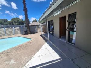 a house with a swimming pool next to a building at Moonlight Guesthouse in Bloemfontein