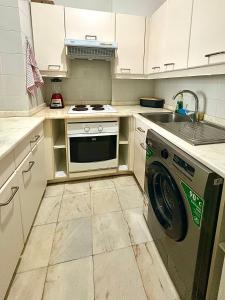 a kitchen with a washing machine and a sink at Polana View Apartment I in Maputo