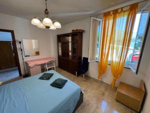 a bedroom with a bed and a table and windows at Appartamento ad Andora a soli 5' dal mare in Laigueglia