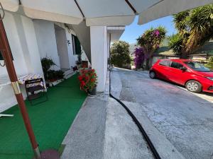a red car parked on the side of a house at Appartamento ad Andora a soli 5' dal mare in Laigueglia