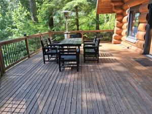 ein Holzdeck mit Tisch und Stühlen auf einer Hütte in der Unterkunft AlpenView in Glacier