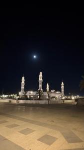 a view of a city at night with the moon at Qubaa Soul Studio 2-3 in Medina