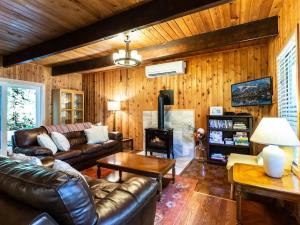 a living room with a leather couch and a fireplace at Forest View Chalet in Glacier