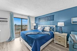 a blue bedroom with a bed and a window at Beach View Condo in Myrtle Beach