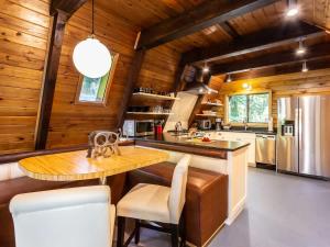a kitchen with wooden walls and a wooden table and chairs at Forest View Chalet in Glacier