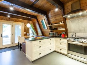 a large kitchen with white cabinets and a table at Forest View Chalet in Glacier +25 photos