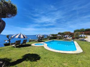 a swimming pool with chairs and umbrellas next to the water at Oia Mar & Relax in Oya +22 photos