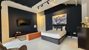 a bedroom with a king sized bed and a couch at Garden Suite in Oya