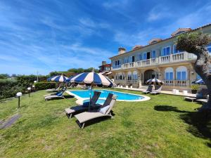 a resort with a pool and chairs and a building at Garden Suite in Oya