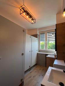 a room with a bathroom with a sink and a window at Fajrant Rooms Katowice in Katowice +28 photos