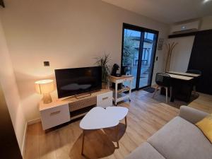 a living room with a flat screen tv and a couch at Studio Cotentin Evas'yon in Feugères