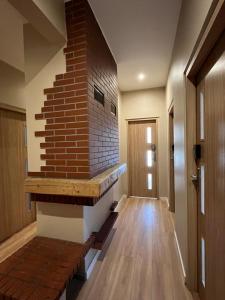 a living room with a brick fireplace and a staircase at Fajrant Rooms Katowice in Katowice
