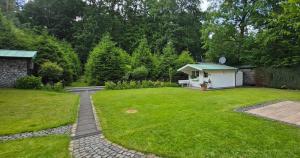 a garden with a small white shed in the yard at Villa Albert in Euskirchen