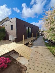 a small building with a wooden deck next to it at Studio Cotentin Evas'yon in Feugères