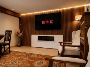 a living room with a tv on a wall at Vila Iepurasul Sinaia in Sinaia