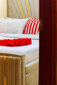 two beds with red and white pillows in a room at Cherve BnB in Nakuru