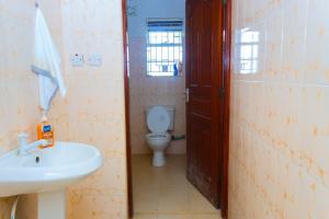 a bathroom with a white sink and a toilet at Cherve BnB in Nakuru +8 photos