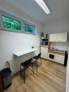 a kitchen with a table and two chairs in a room at City Apartment in Siegen