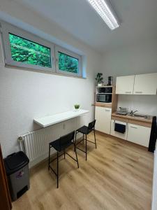a kitchen with two chairs and a table and two windows at City Apartment in Siegen +13 photos