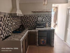 a kitchen with black and white tiles on the wall at Studio avec terrasse privée sans vis-à-vis in Essaouira