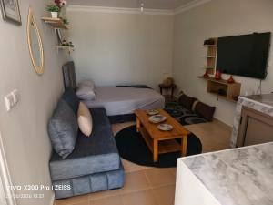 a small living room with a couch and a tv at Studio avec terrasse privée sans vis-à-vis in Essaouira