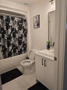 ein Badezimmer mit Toilette und schwarz-weißem Duschvorhang in der Unterkunft Light House in Riverview