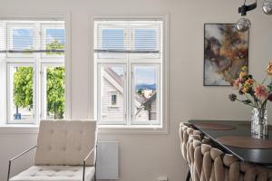 a dining room with a table and two windows at The Brown Door in Stavanger