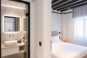 a bedroom with a white bed and a sink at Veneto Sea View Apartments in Stalís +50 photos