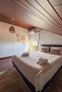 a bedroom with a large bed with a wooden ceiling at Casa da presa in Ponte de Lima